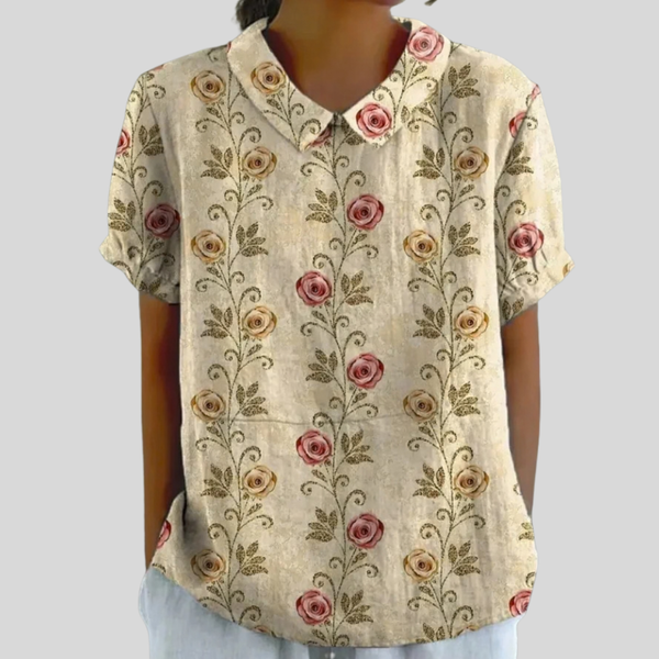 Vloeiende dames top met bloemenprint en nette polokraag die mooi over het lichaam valt