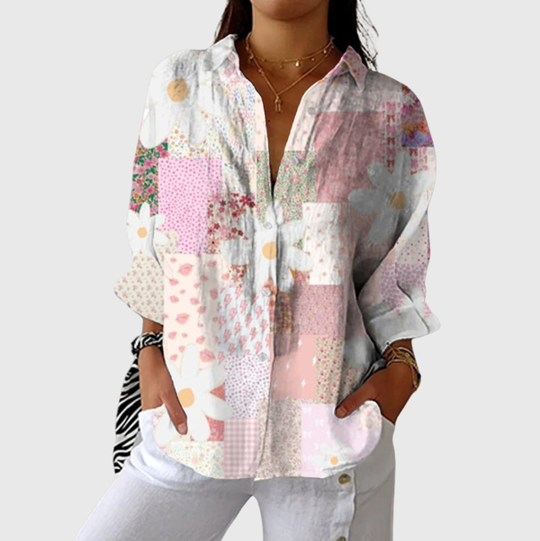 Luchtige zomerblouse met grafische print in heldere kleuren, gedragen op een witte broek