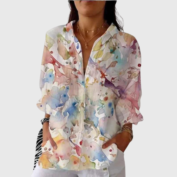 Vrolijke damesblouse met luchtige print in warme kleuren, gedragen bij een spijkerbroek