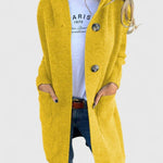 Lang gebreid vest met knoopsluiting voor dames, gedragen over een effen top en een jeans