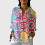 Soepel vallende damesblouse met kleurrijke print, gedragen los over een spijkerbroek