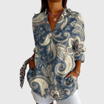 Kleurrijke zomerblouse met vlotte pasvorm en frisse print, gedragen op een lichte broek