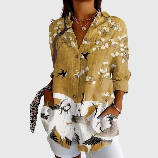 Kleurrijke damesblouse met opvallende print en ruime pasvorm, los over een broek gedragen