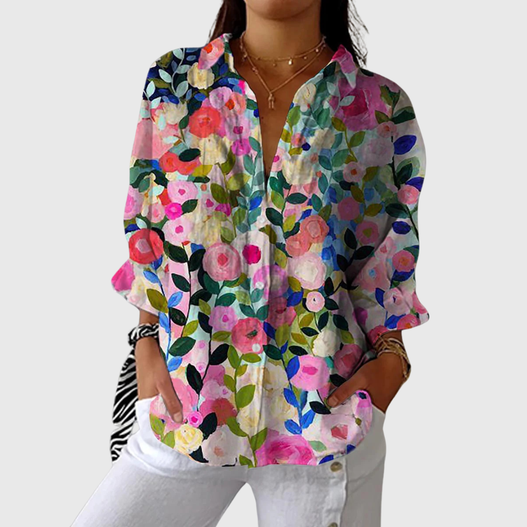 Luchtige damesblouse met kleurrijke bloemenprint en lange mouwen, los gedragen op een broek
