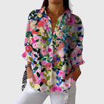 Luchtige damesblouse met kleurrijke bloemenprint en lange mouwen, los gedragen op een broek