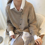 Oversized vest met v-hals en knopen voor dames, gedragen over een effen top en een jeans